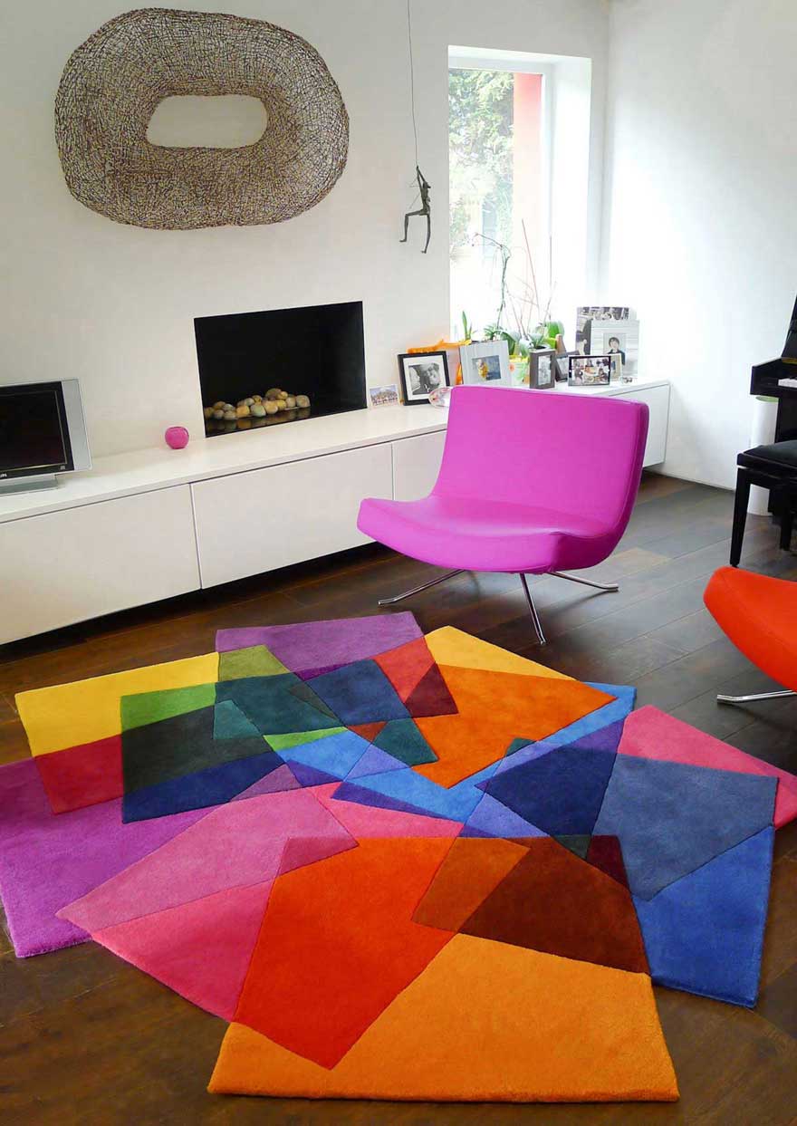 White Living Room with Pink Chair and Colorful Rugs