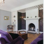 Warm Living Room with Purple Sofa and Fireplace Mantels