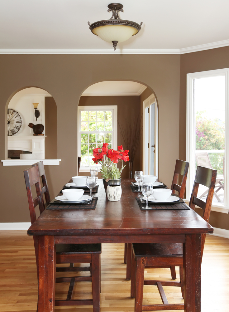 Nice place setting on wood dining room table with vase