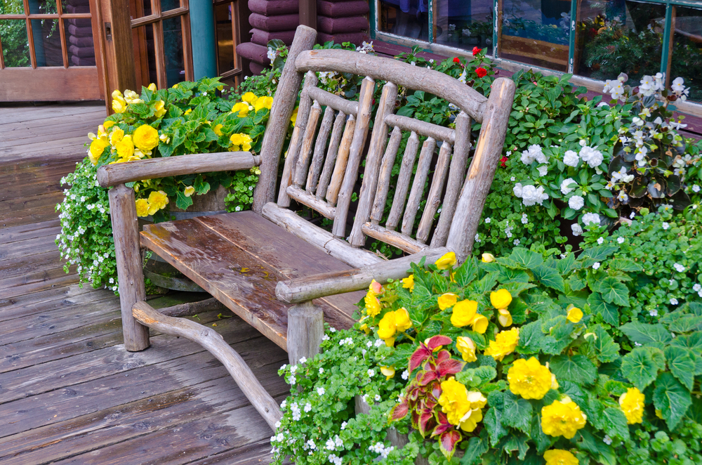 Wood backyard bench in flowers