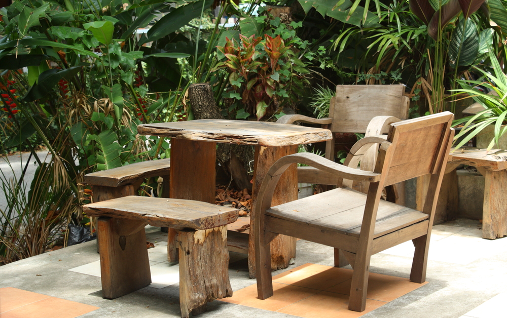 Wooden table and chairs in lush garden